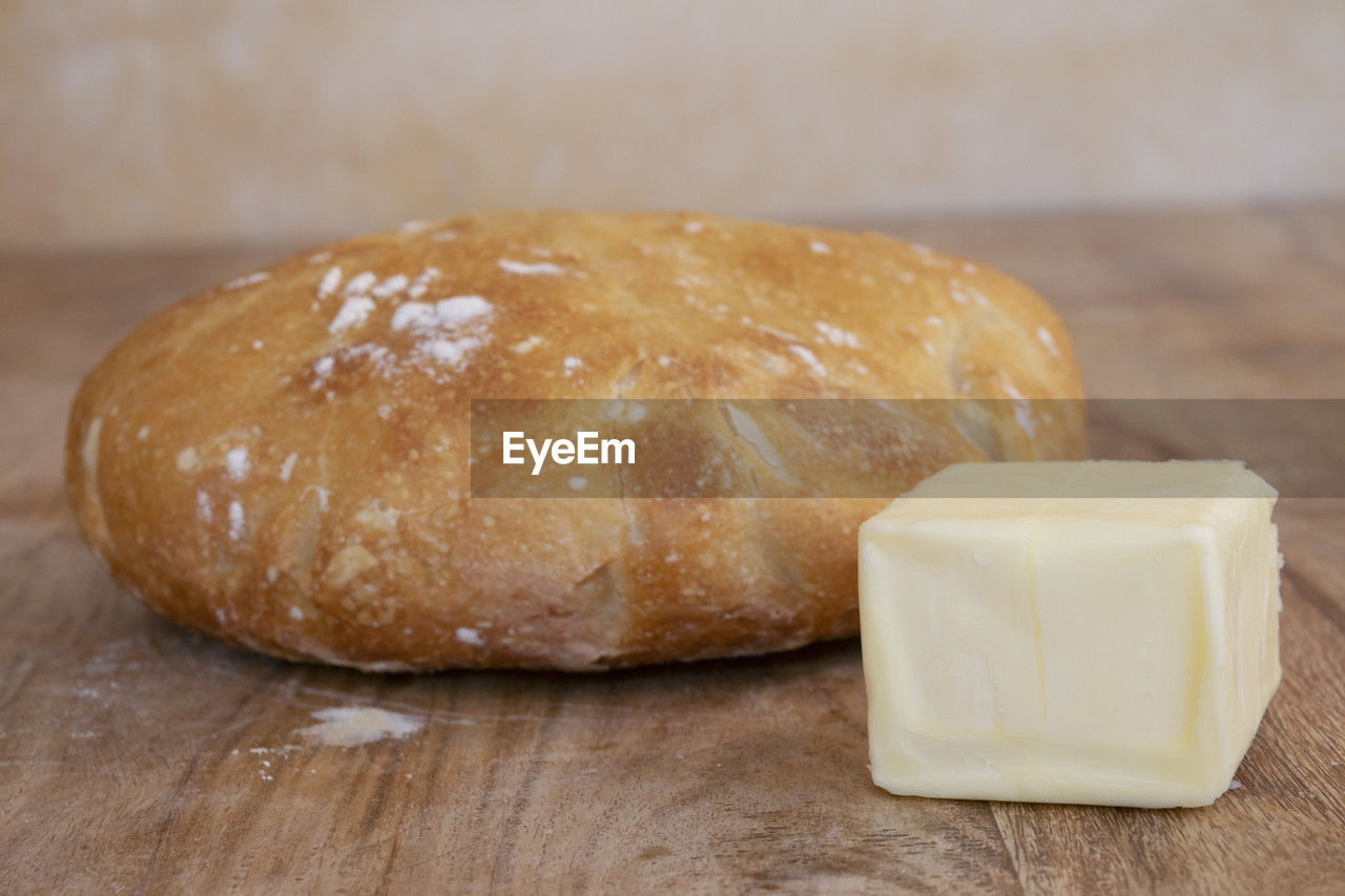 food and drink, food, freshness, bread, indoors, wellbeing, close-up, table, wood, healthy eating, baked, no people, breakfast, still life, simplicity, loaf of bread, rustic, focus on foreground, dessert, meal, cutting board, store, flour, dairy