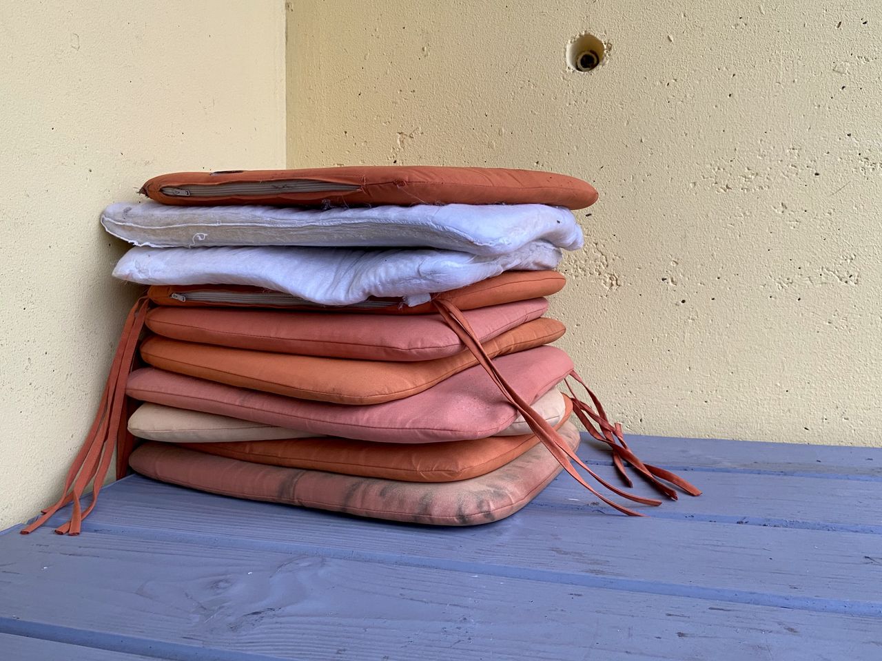 Stack of cushions on table against wall