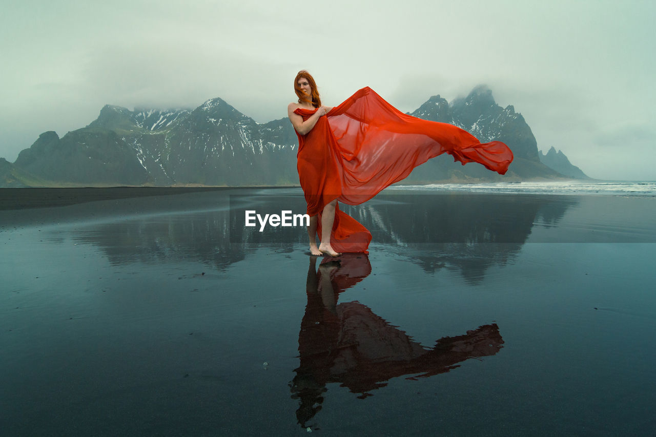 Beautiful woman in red dress on reynisfjara beach scenic photography