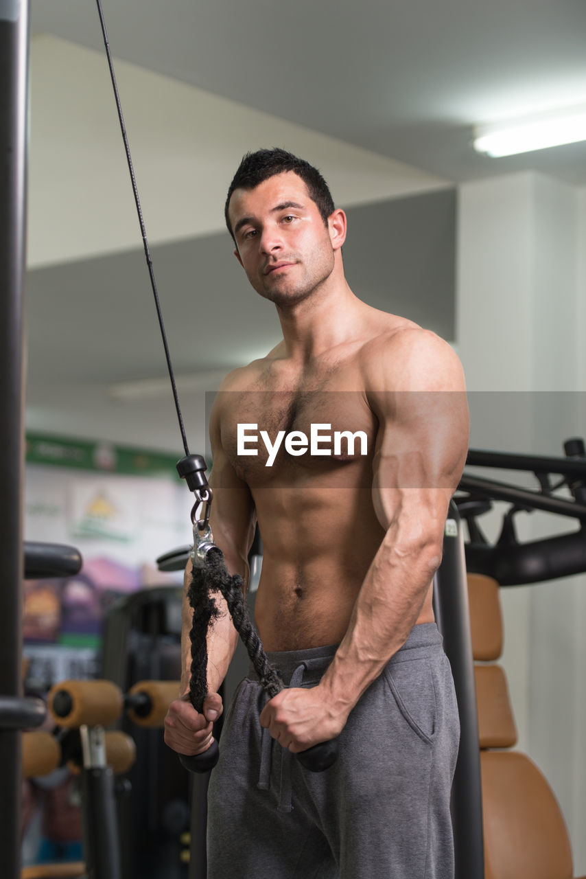 Shirtless muscular man exercising in gym