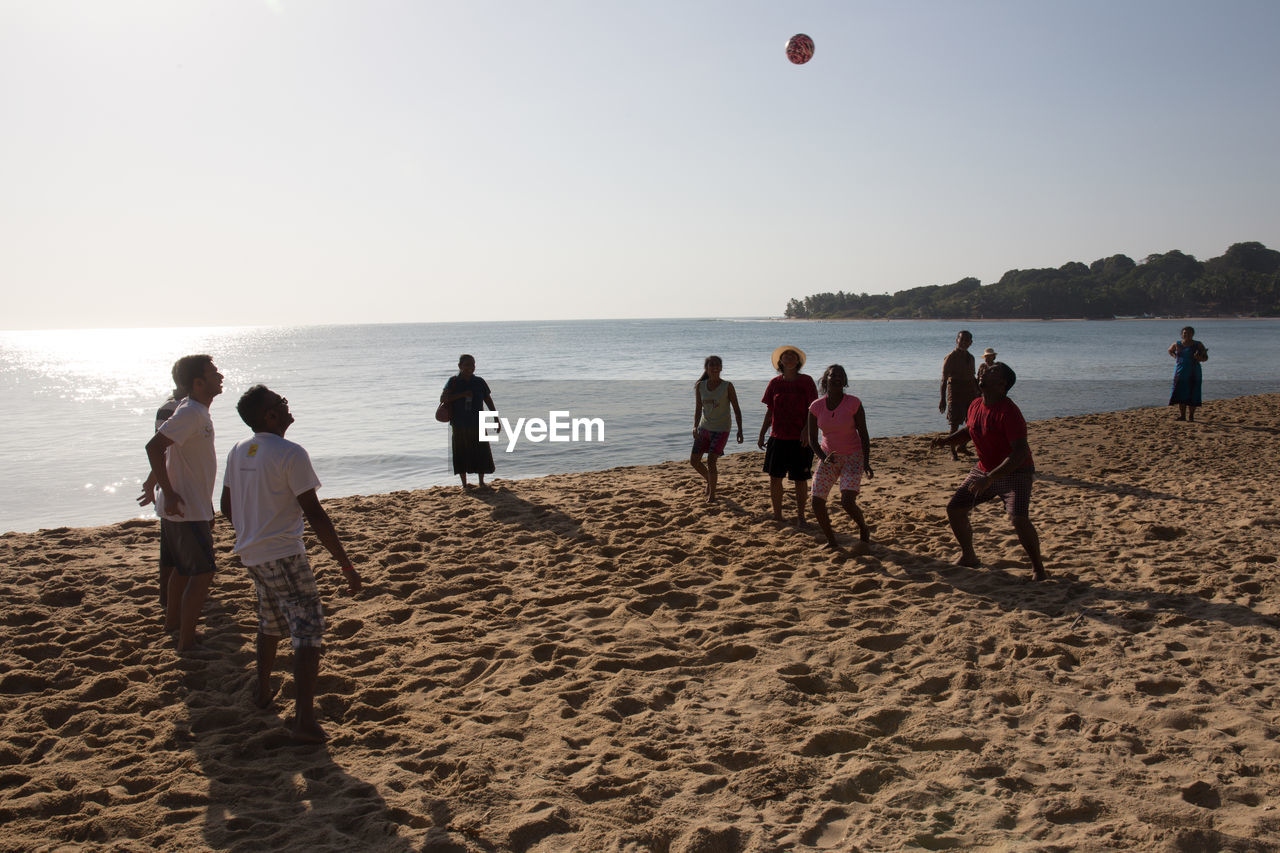 PEOPLE ENJOYING ON BEACH AGAINST SKY