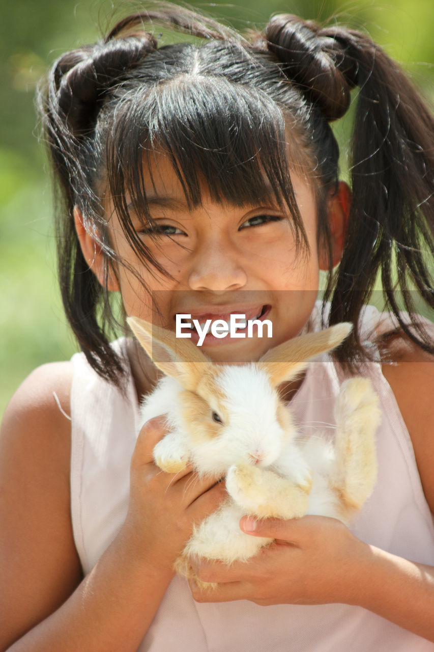 Portrait of cute girl smiling with a rabbit 