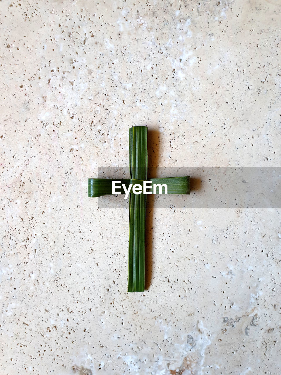 HIGH ANGLE VIEW OF CROSS ON GREEN TABLE