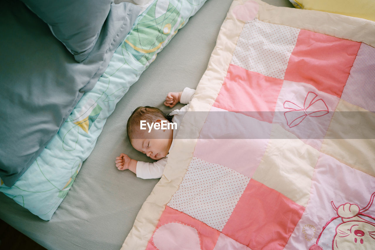 High angle view of baby boy sleeping on bed