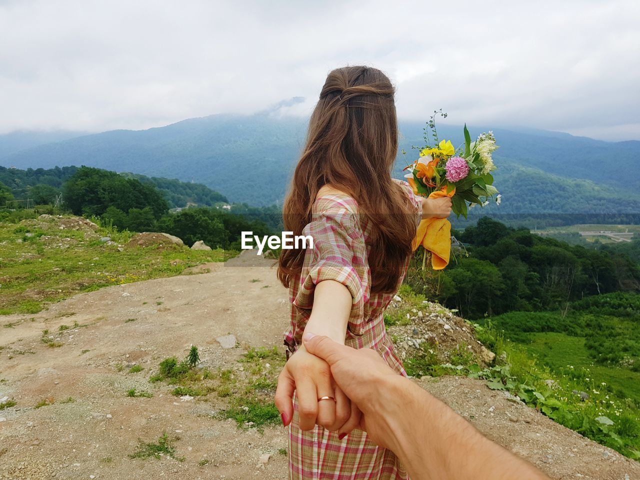 Man holding woman hand in nature