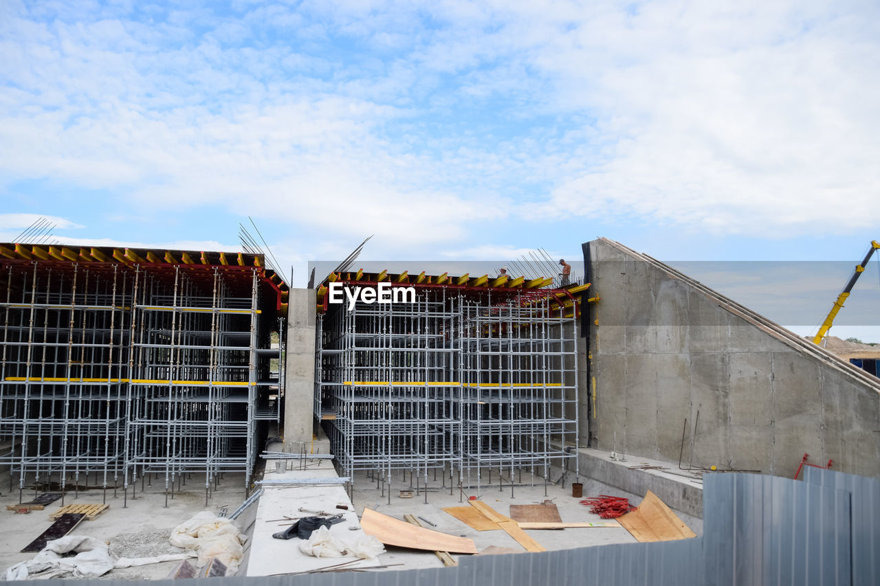 LOW ANGLE VIEW OF METALLIC STRUCTURE ON FENCE AGAINST SKY