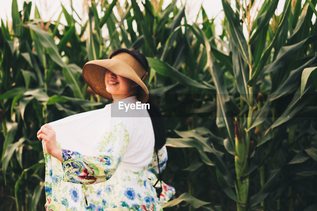 Woman standing by plants on field