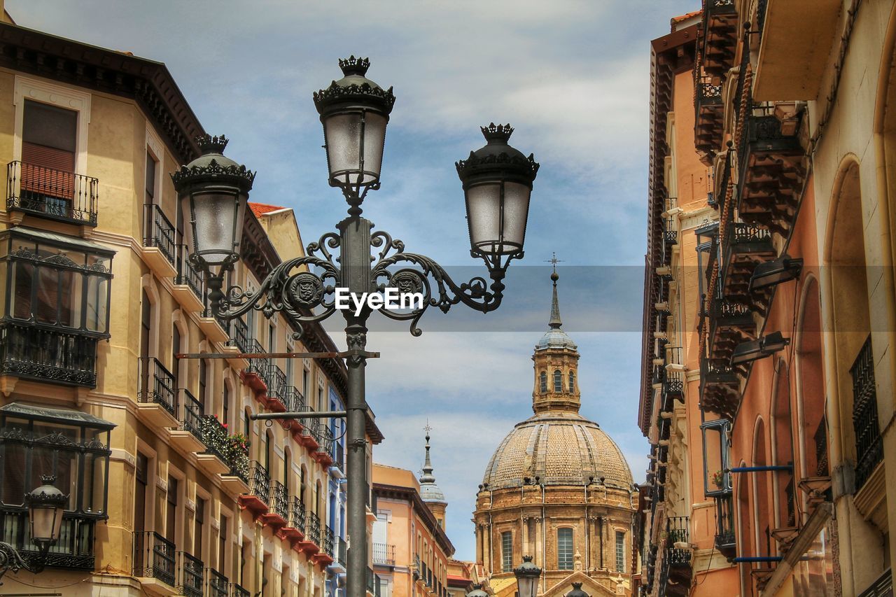 Low angle view of street lights by cathedral-basilica of our lady of the pillar against sky