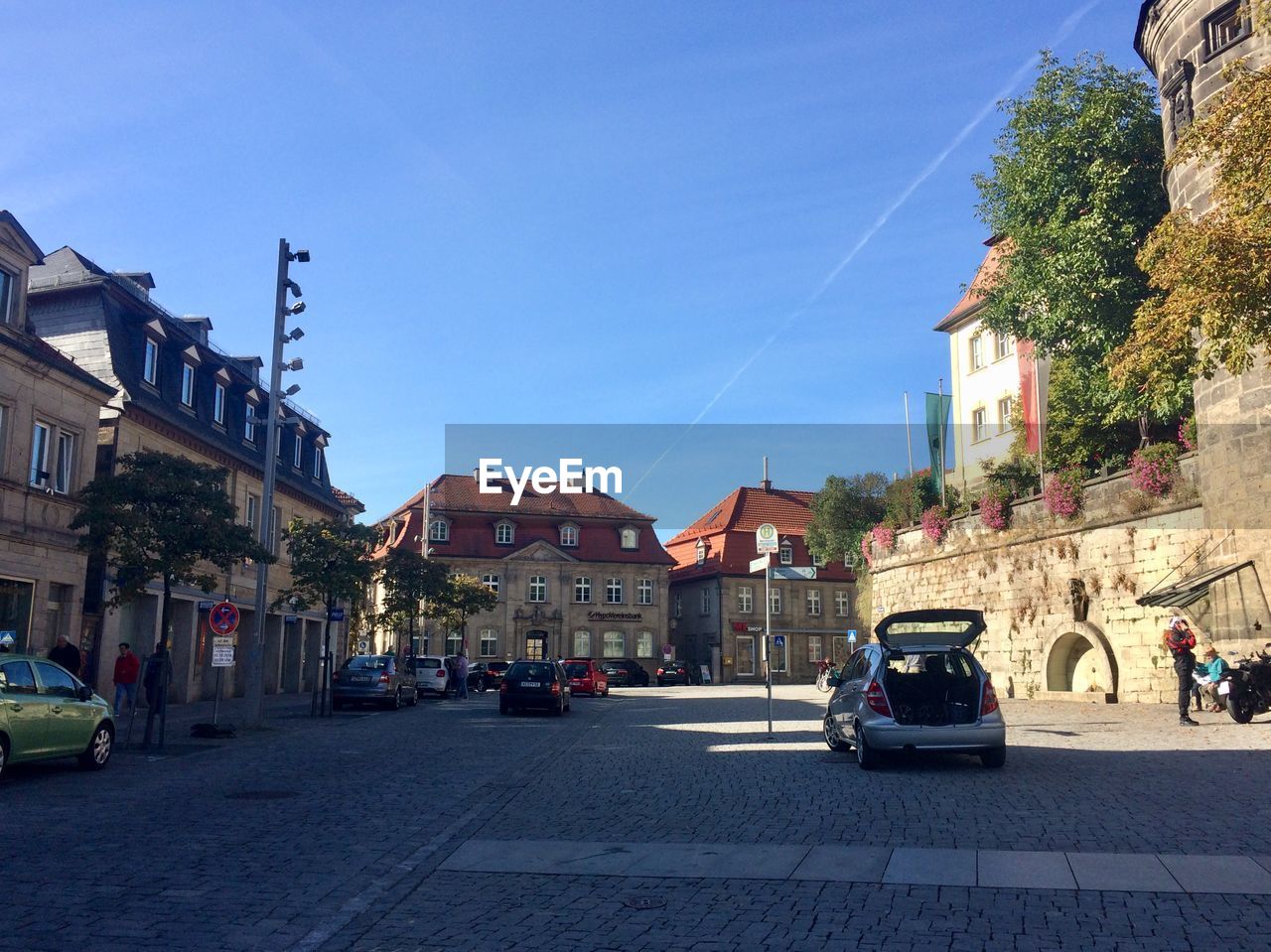 CARS ON STREET AMIDST BUILDINGS IN TOWN