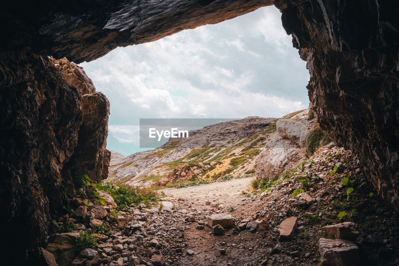 Rock formations by mountains against sky