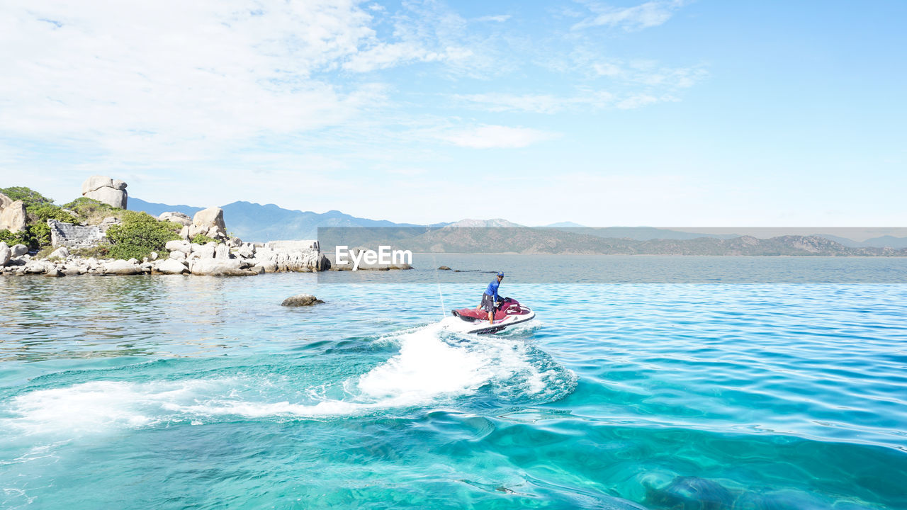 Man jet boating in sea against sky