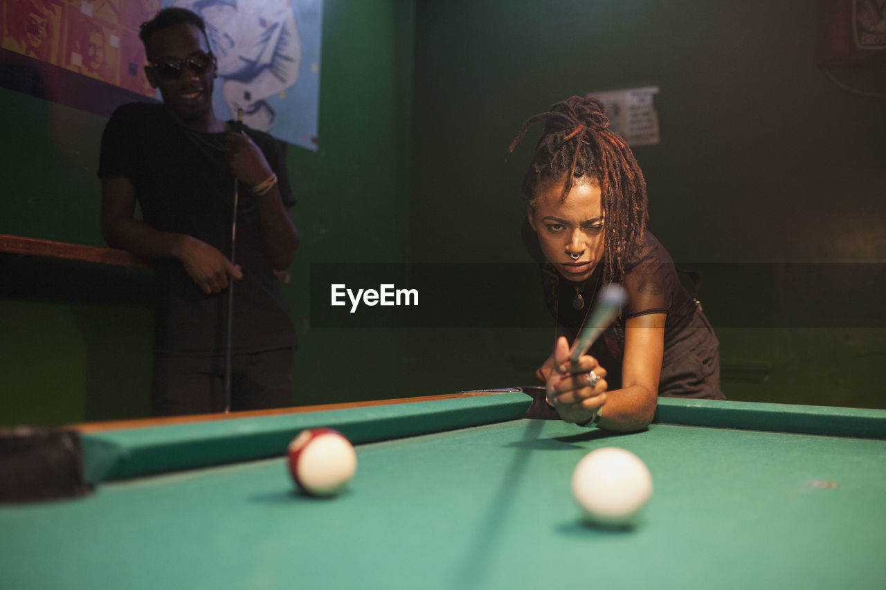 A young woman playing pool.