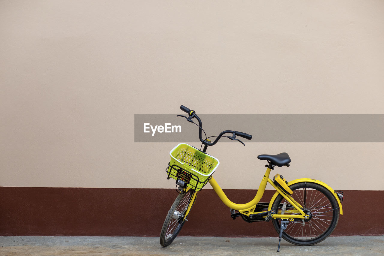 A yellow bicycle parked next to the house leave space for the text.