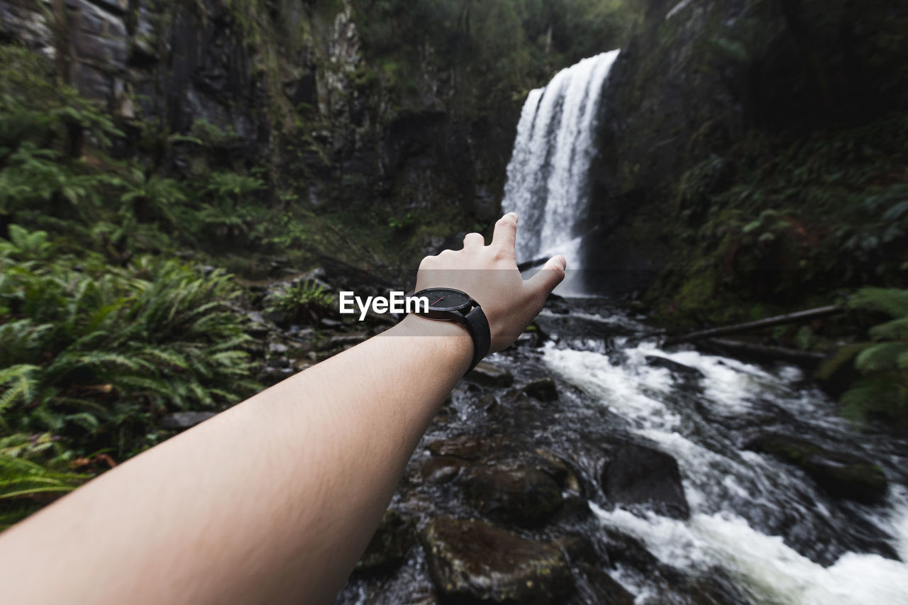 Man reaching for waterfall