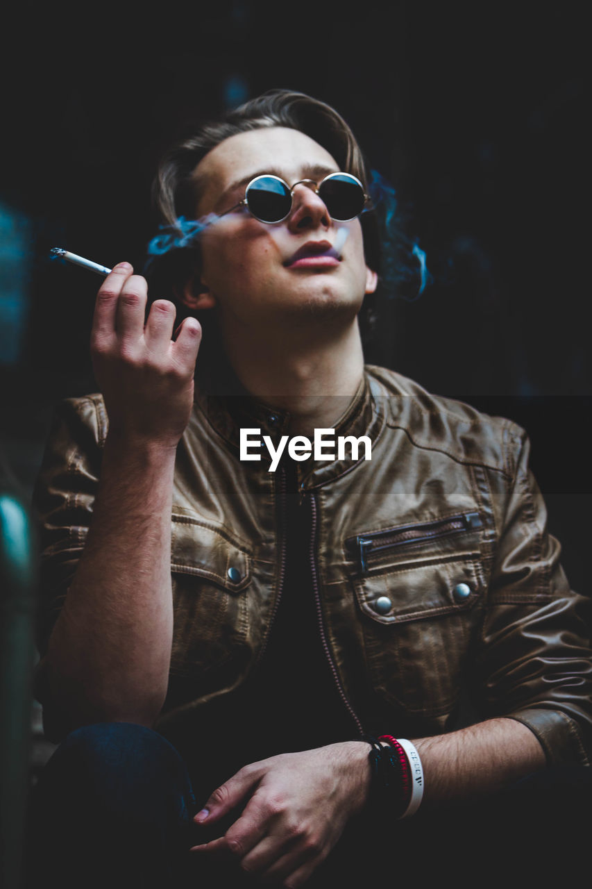 Close-up of man wearing sunglasses smoking cigar