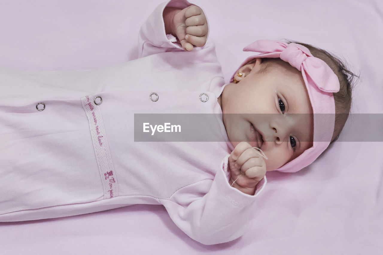 high angle view of cute baby girl lying on bed