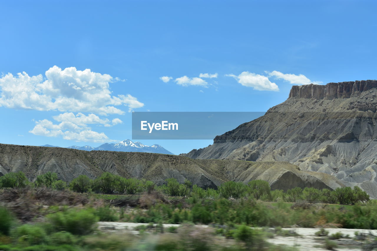 Scenic view of mountains against blue sky