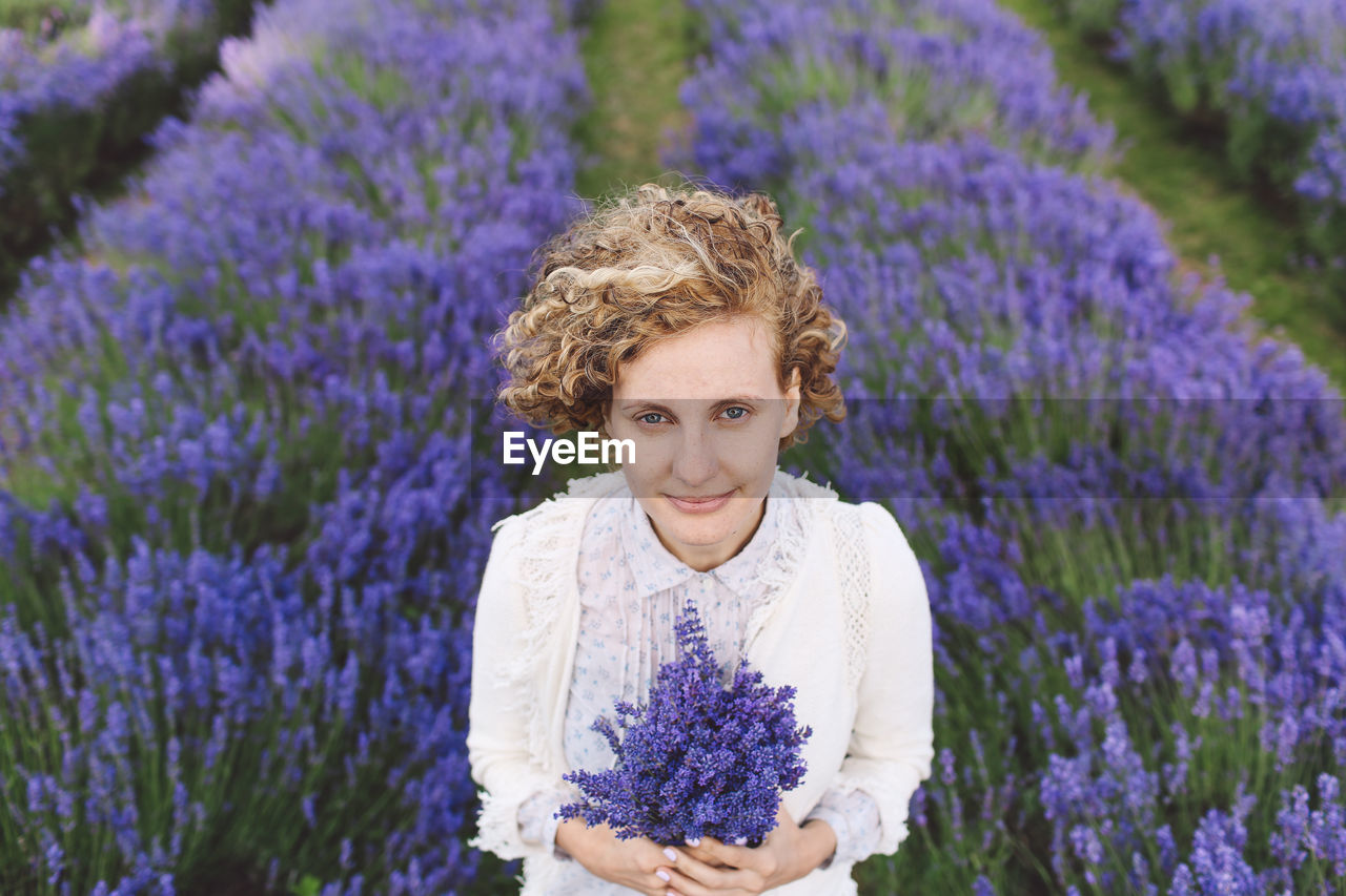 Portrait of woman holding purple flowers