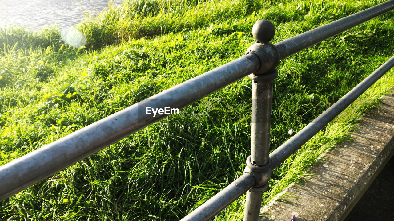 CLOSE-UP OF RAILING BY GRASS