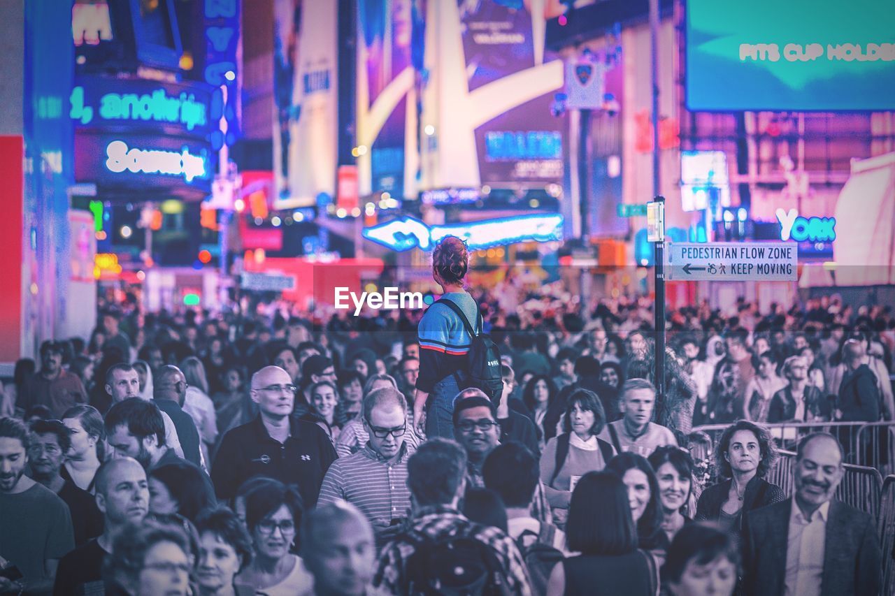 CROWD IN ILLUMINATED CITY