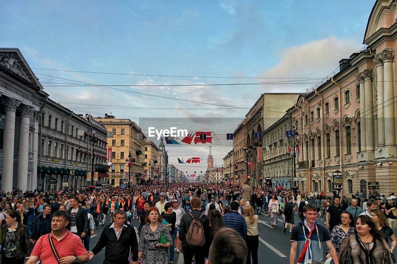 People on street in city against sky