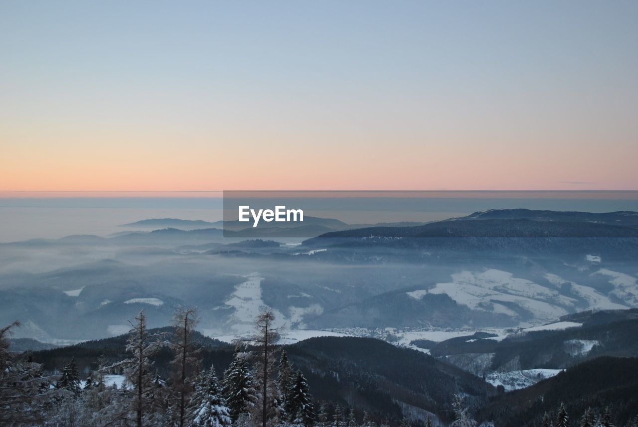 High angle view of fog covered mountains at sunset