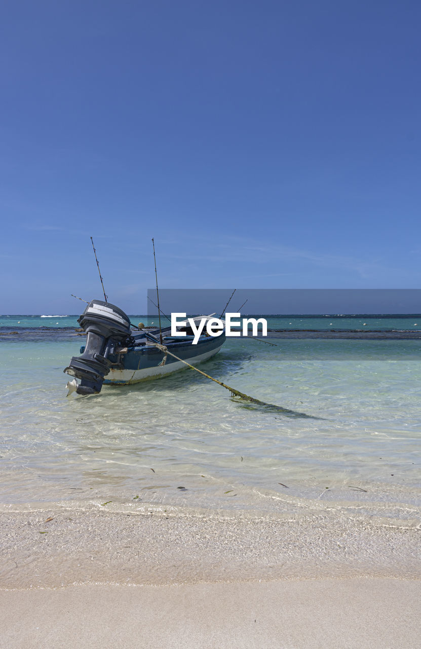 BOAT MOORED ON SEA AGAINST SKY