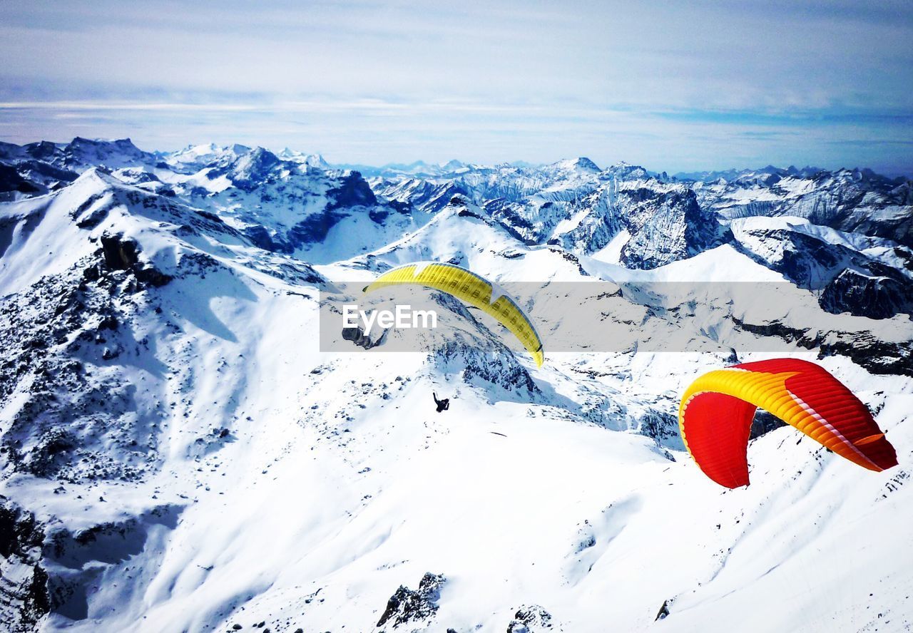 Parachute flying over swiss alps against sky