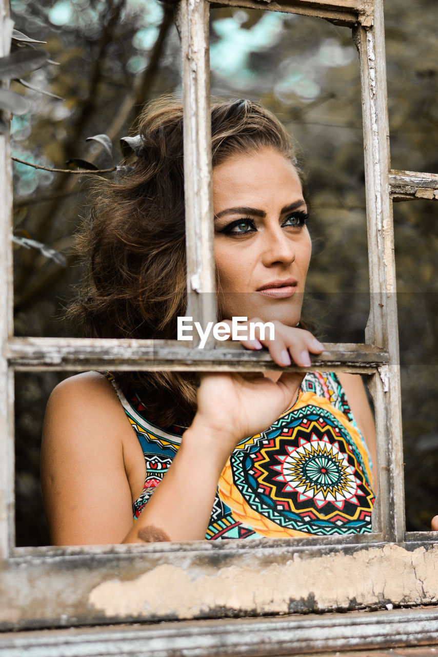 CLOSE-UP PORTRAIT OF WOMAN IN SWING IN CAGE