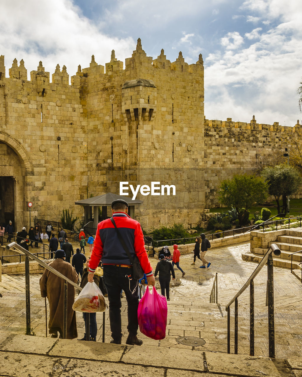 REAR VIEW OF PEOPLE WALKING ON HISTORIC BUILDING