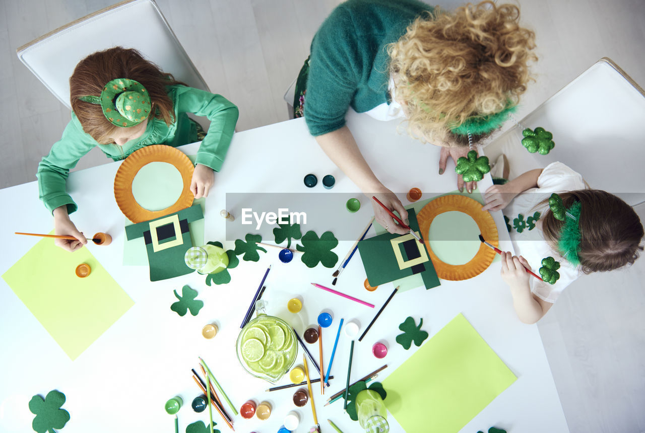 High angle view of mother with daughter making cookies on table