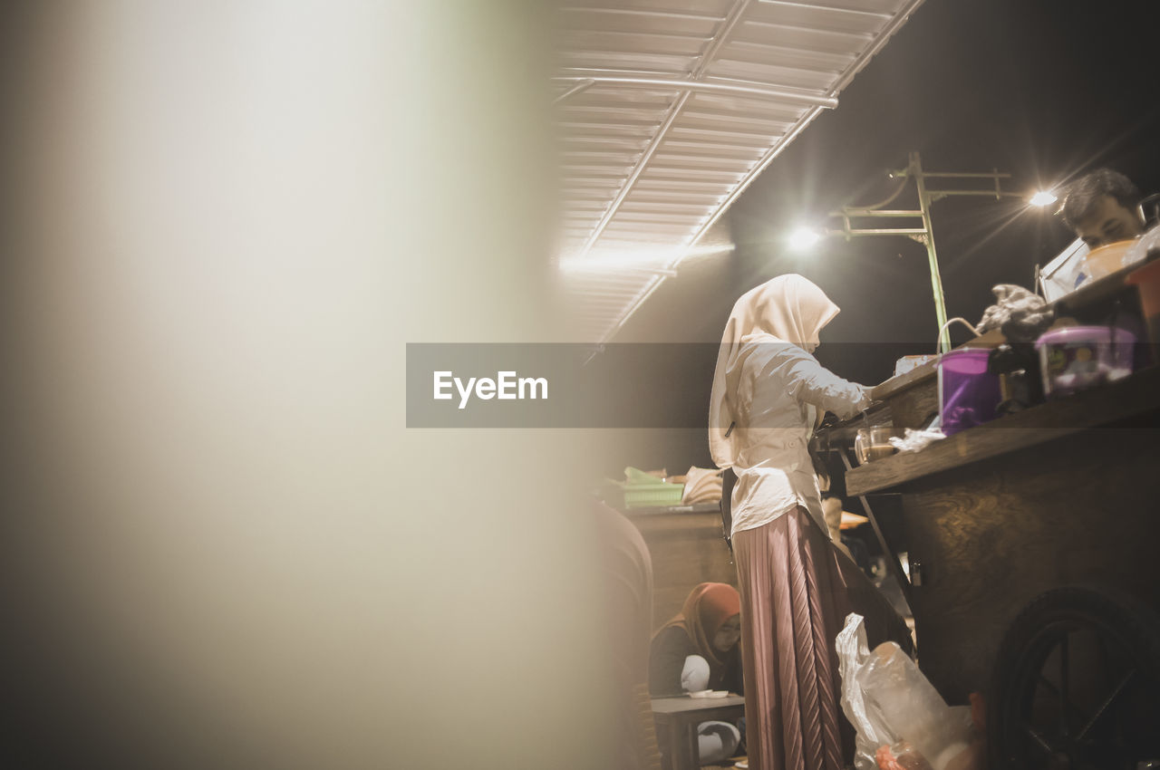 Woman working at market in night