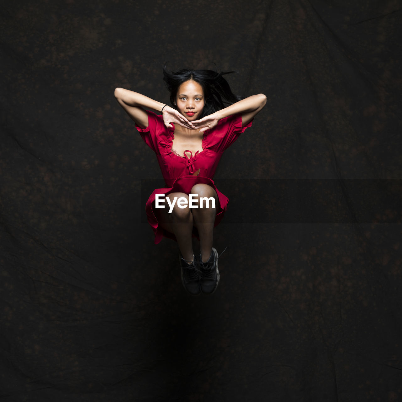 Full length of woman dancing on stage against black background