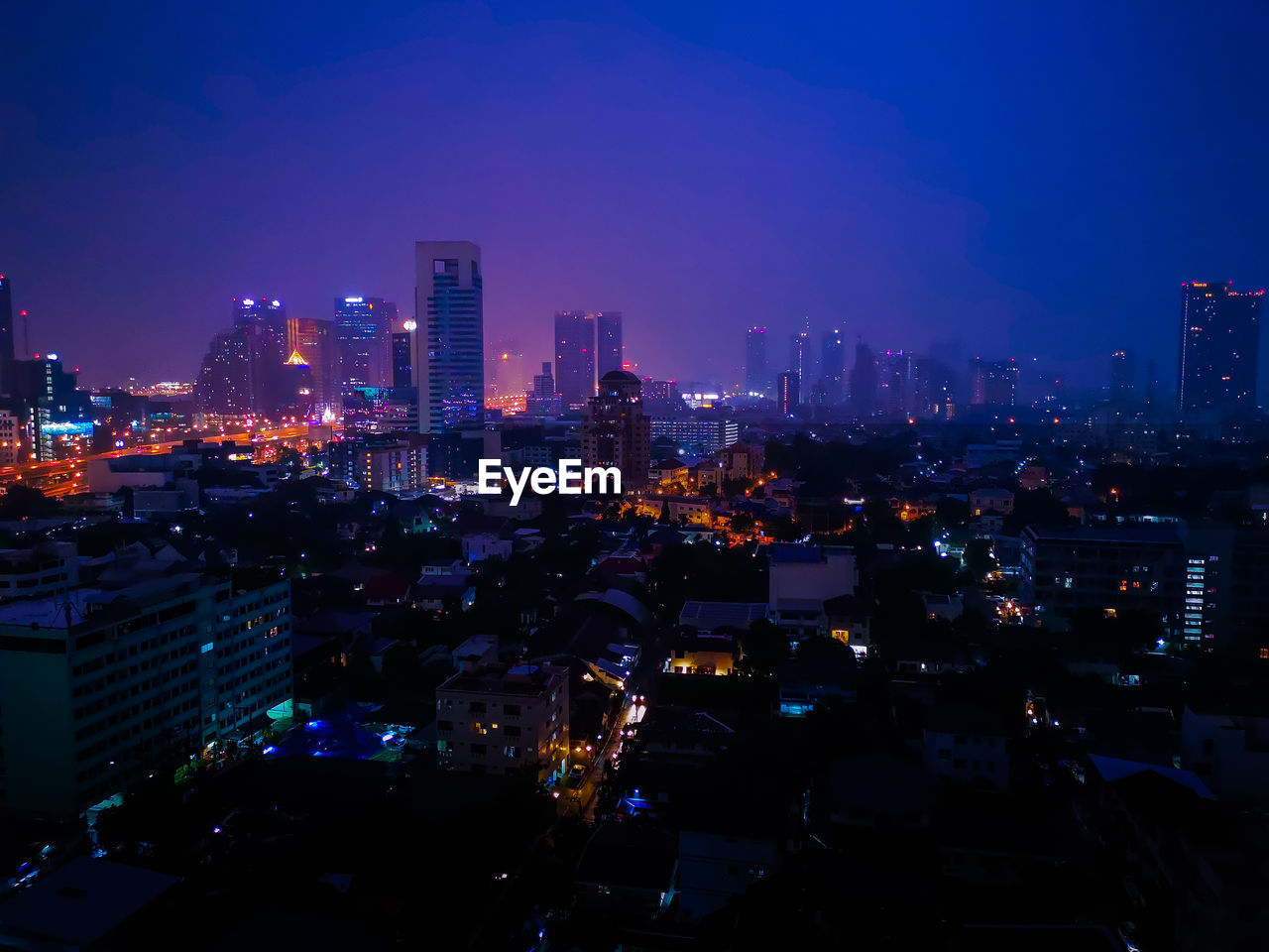 Illuminated buildings in city against sky at night