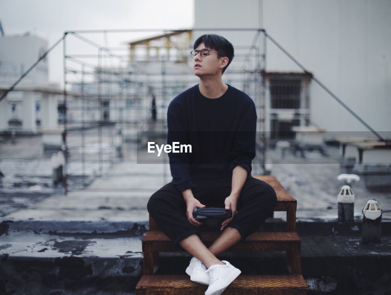 FULL LENGTH OF YOUNG MAN SITTING ON OUTDOORS