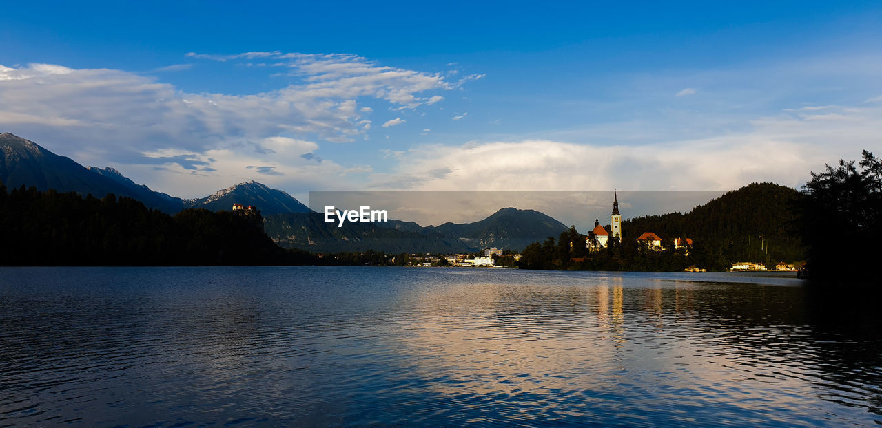 Scenic view of lake by mountains against sky