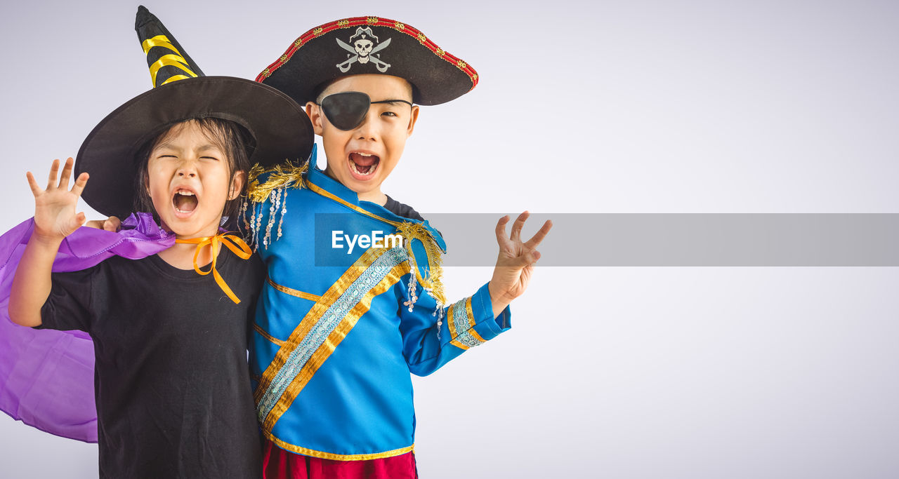 PORTRAIT OF A SMILING BOY AGAINST WHITE BACKGROUND