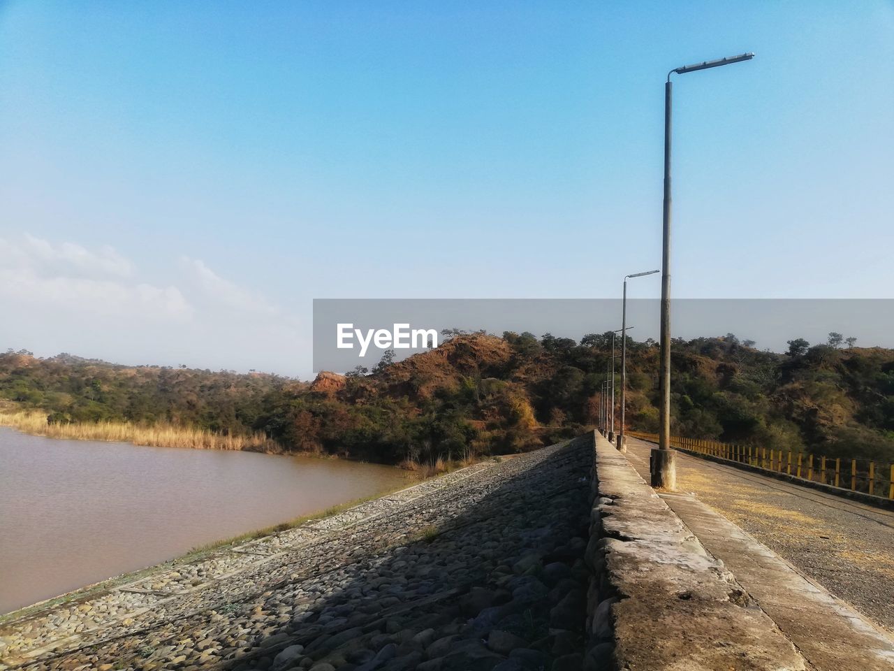ROAD BY TREES AGAINST SKY