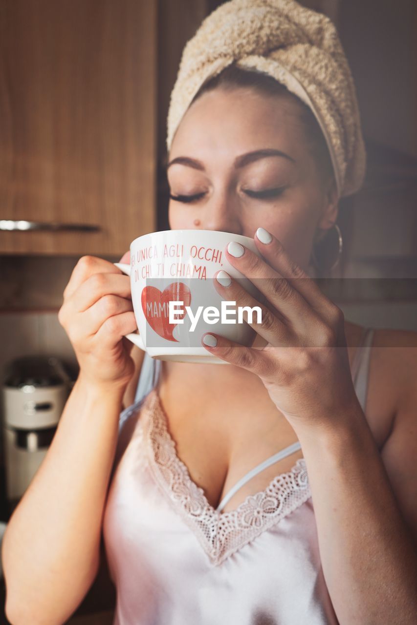 Woman with eyes closed having drink