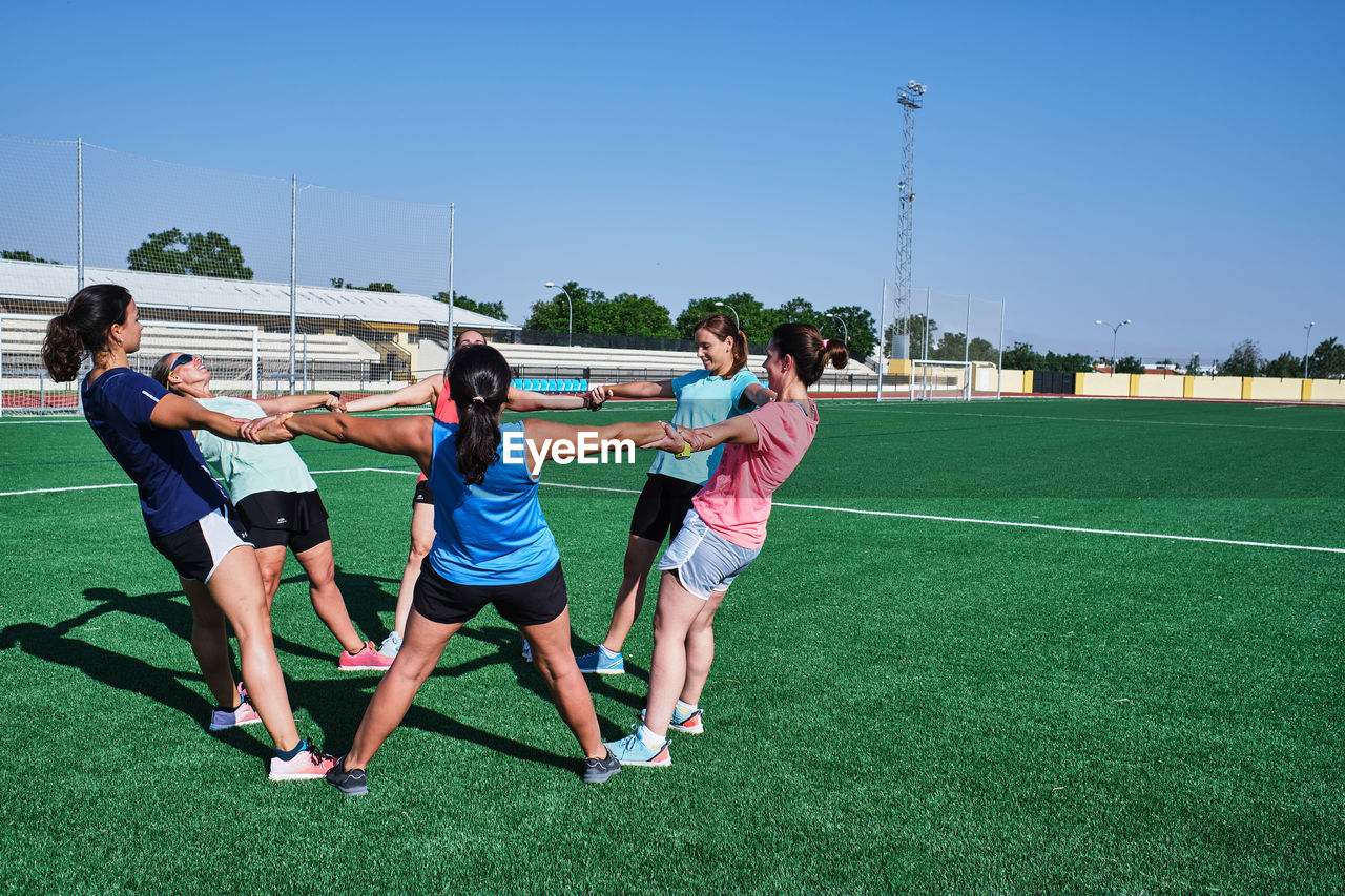 Group of young women practice stretching after their training