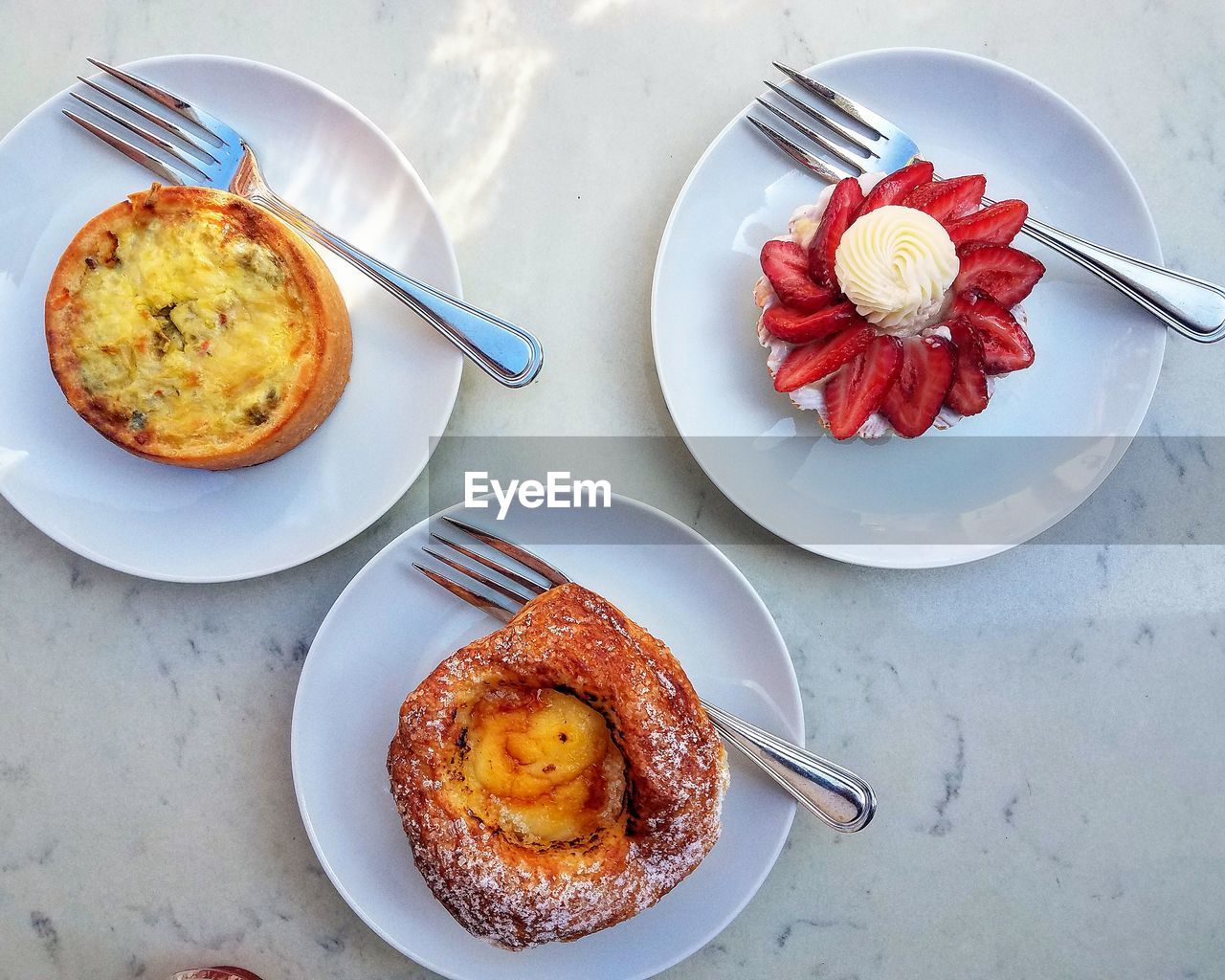 High angle view of various sweet food served in plates on table