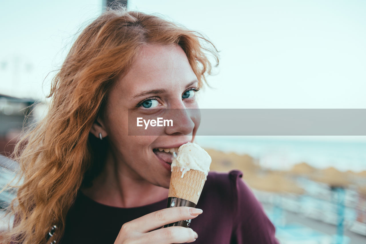 Close-up portrait of young woman eating ice cream