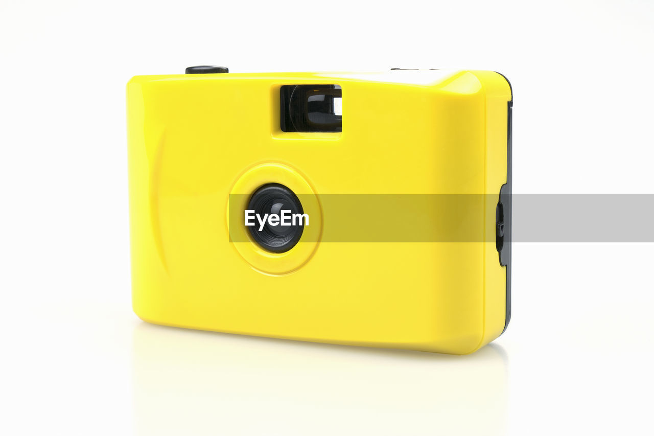 Close-up of yellow camera over white background