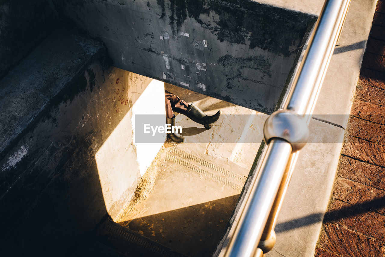 HIGH ANGLE VIEW OF MAN STANDING BY BICYCLE