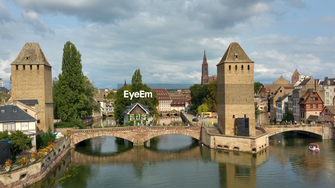 Arch bridge over river against buildings in city