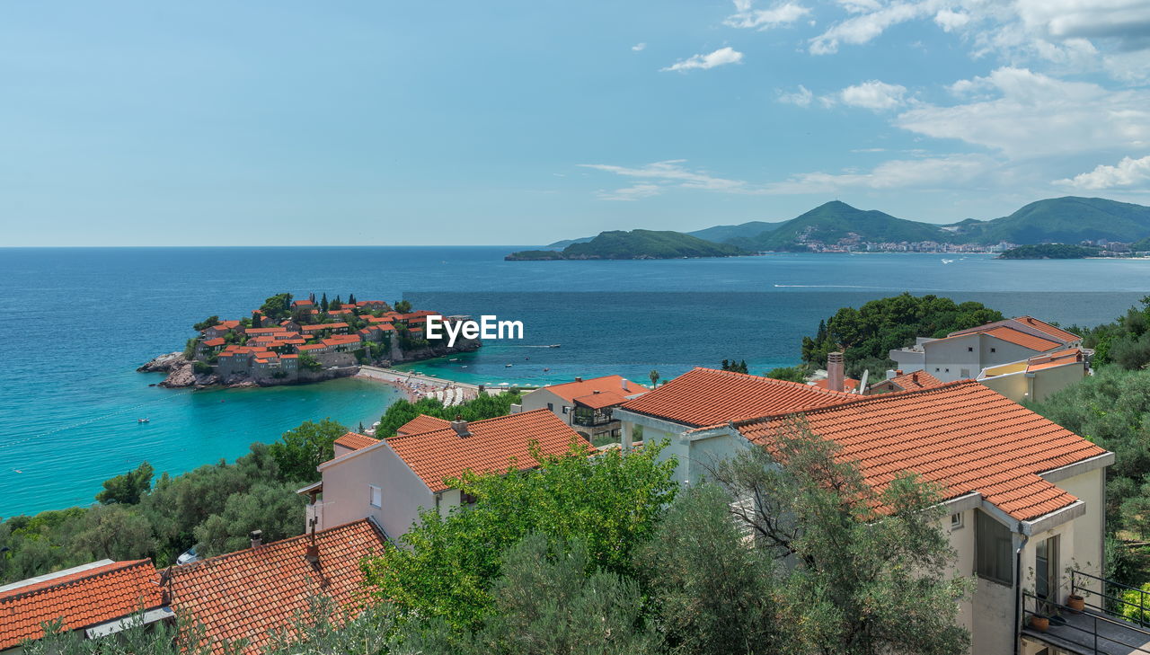 High angle view of buildings by sea against sky