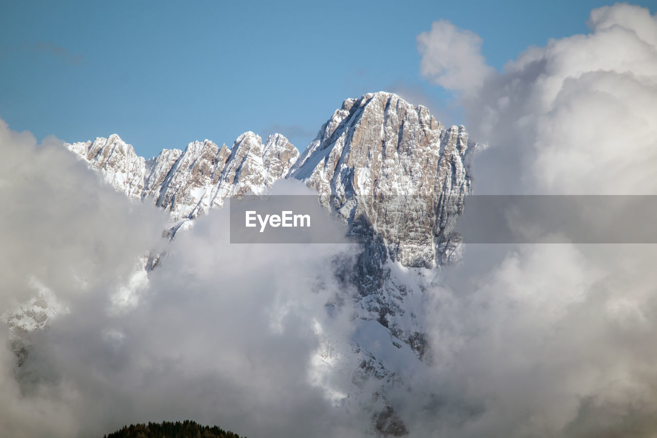 Low angle view of snowcapped mountains against sky