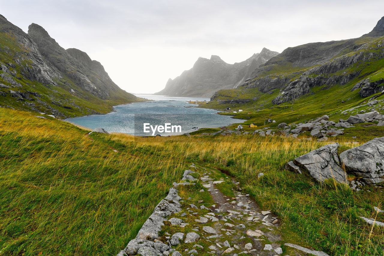 Hiking trail leading to remote village vinstad at the coast and mountains in lofoten norway