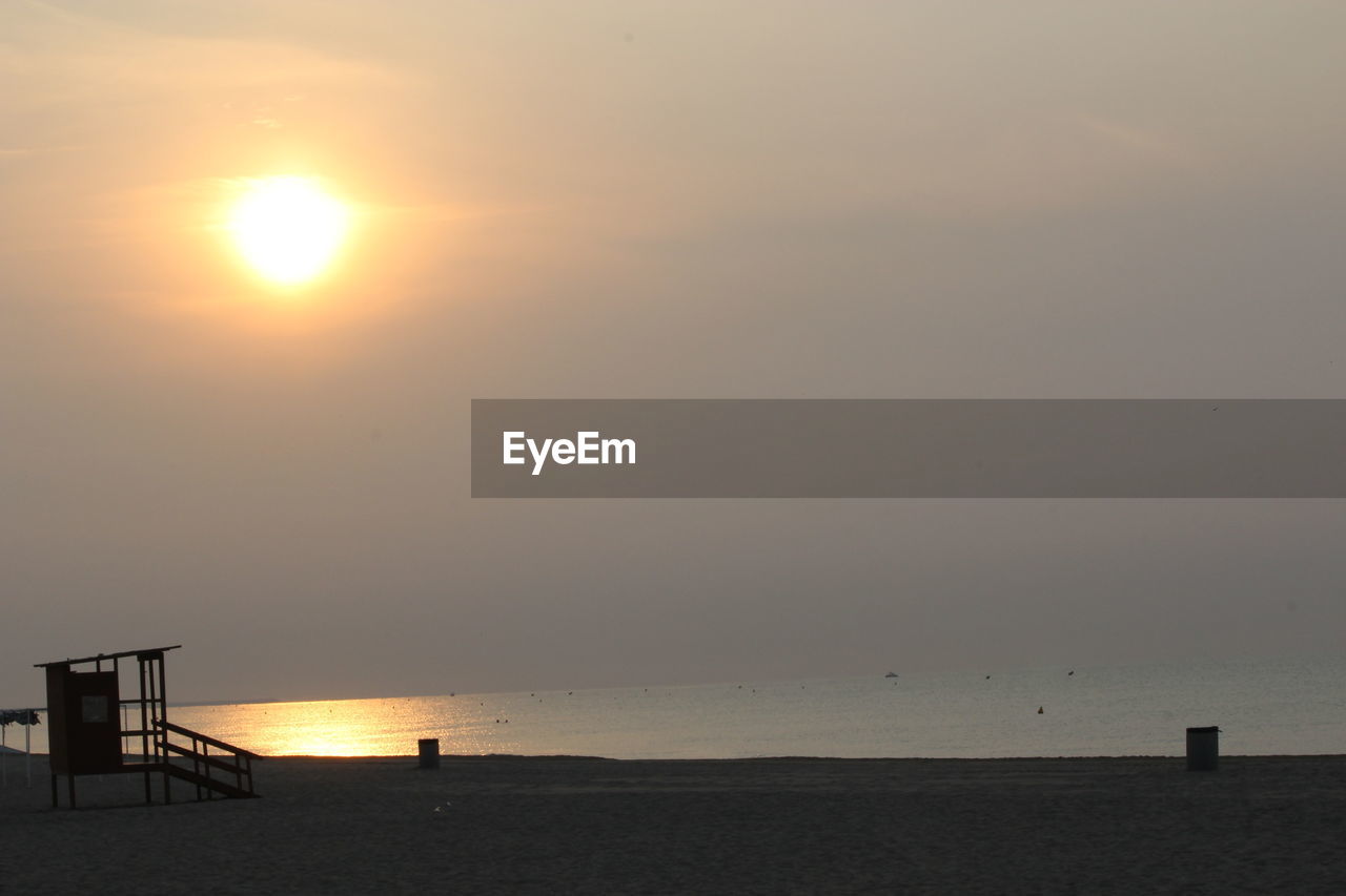 SCENIC VIEW OF BEACH AGAINST SKY AT SUNSET