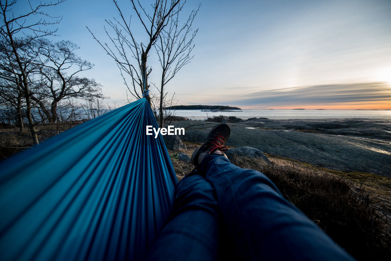 Low section of man relaxing on hammock